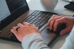 A man working on a black laptop.