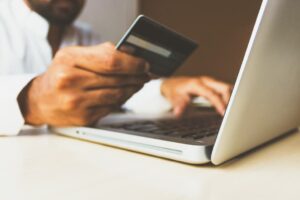 A man using a credit card to buy something on a laptop.