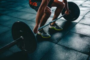 A man picking up a barbell.