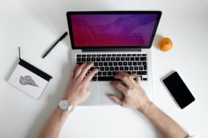 Overhead view of hands typing on a laptop.