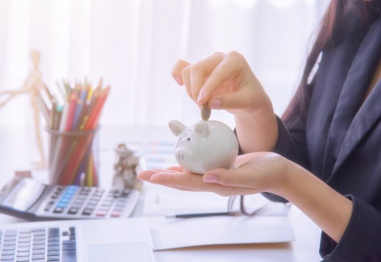 Saving money into a piggy bank.
